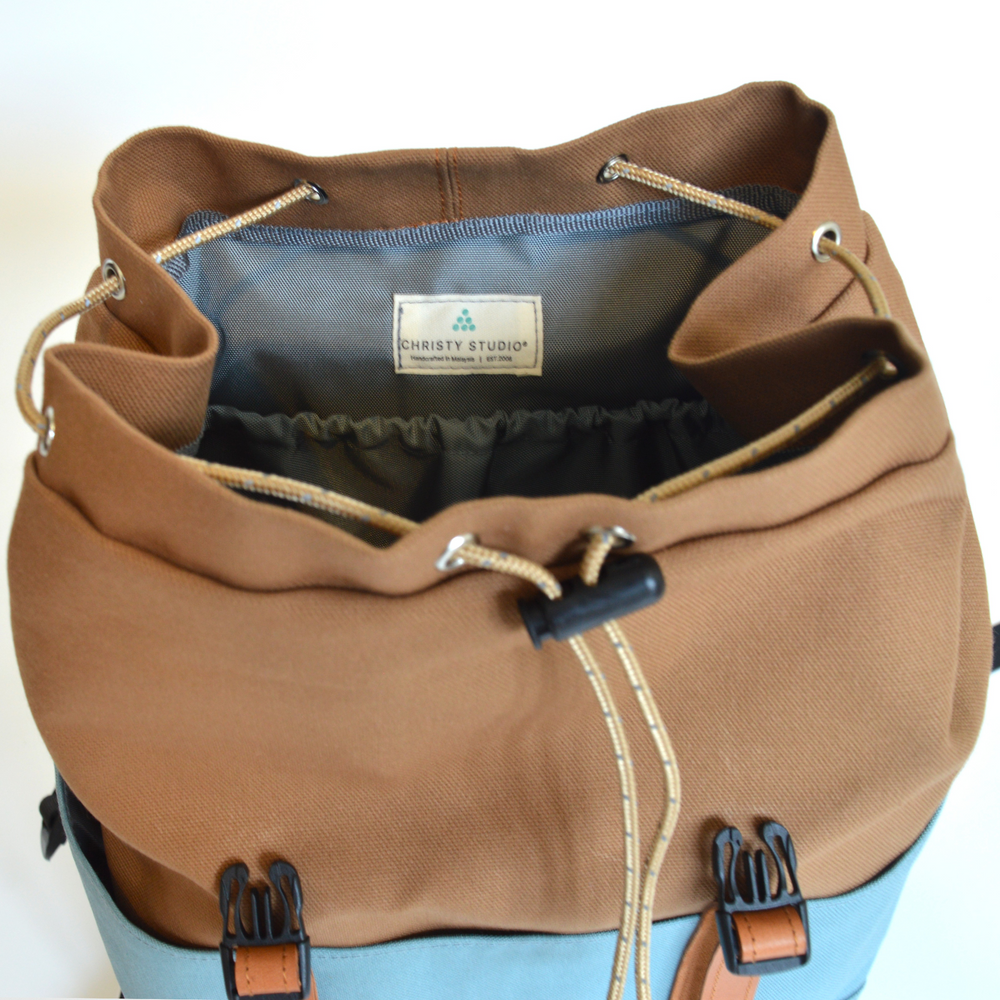 Brown backpack with visible brand label on a white background