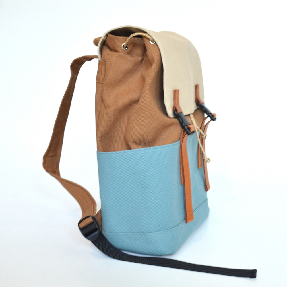 Two-toned backpack with beige top and blue bottom on a white background