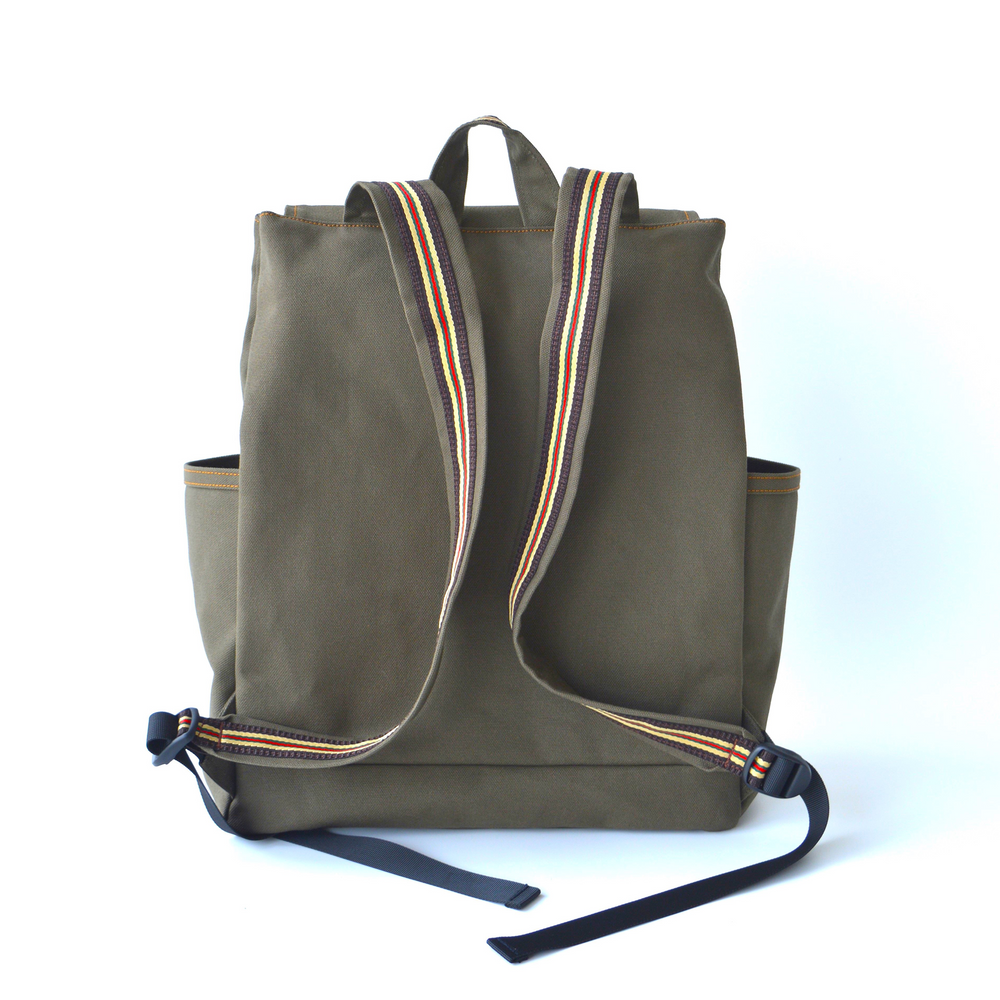 Green backpack with striped straps on a white background