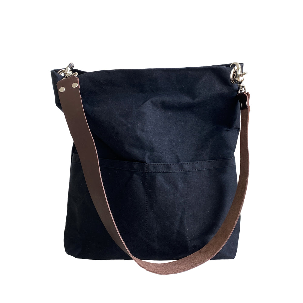 Black shoulder bag with a brown strap on a white background
