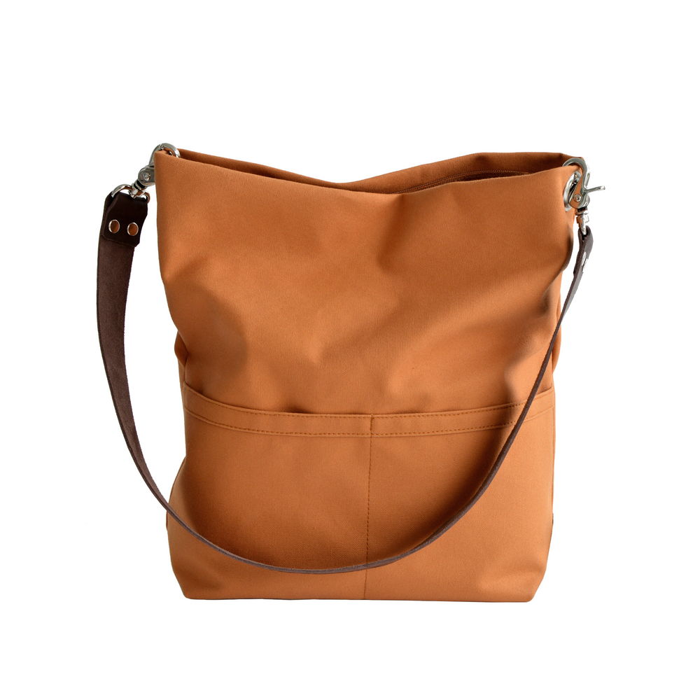 Orange shoulder bag with leather straps on a white background
