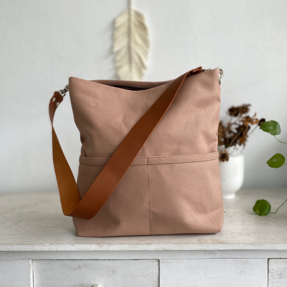 Light brown shoulder bag against plain background.